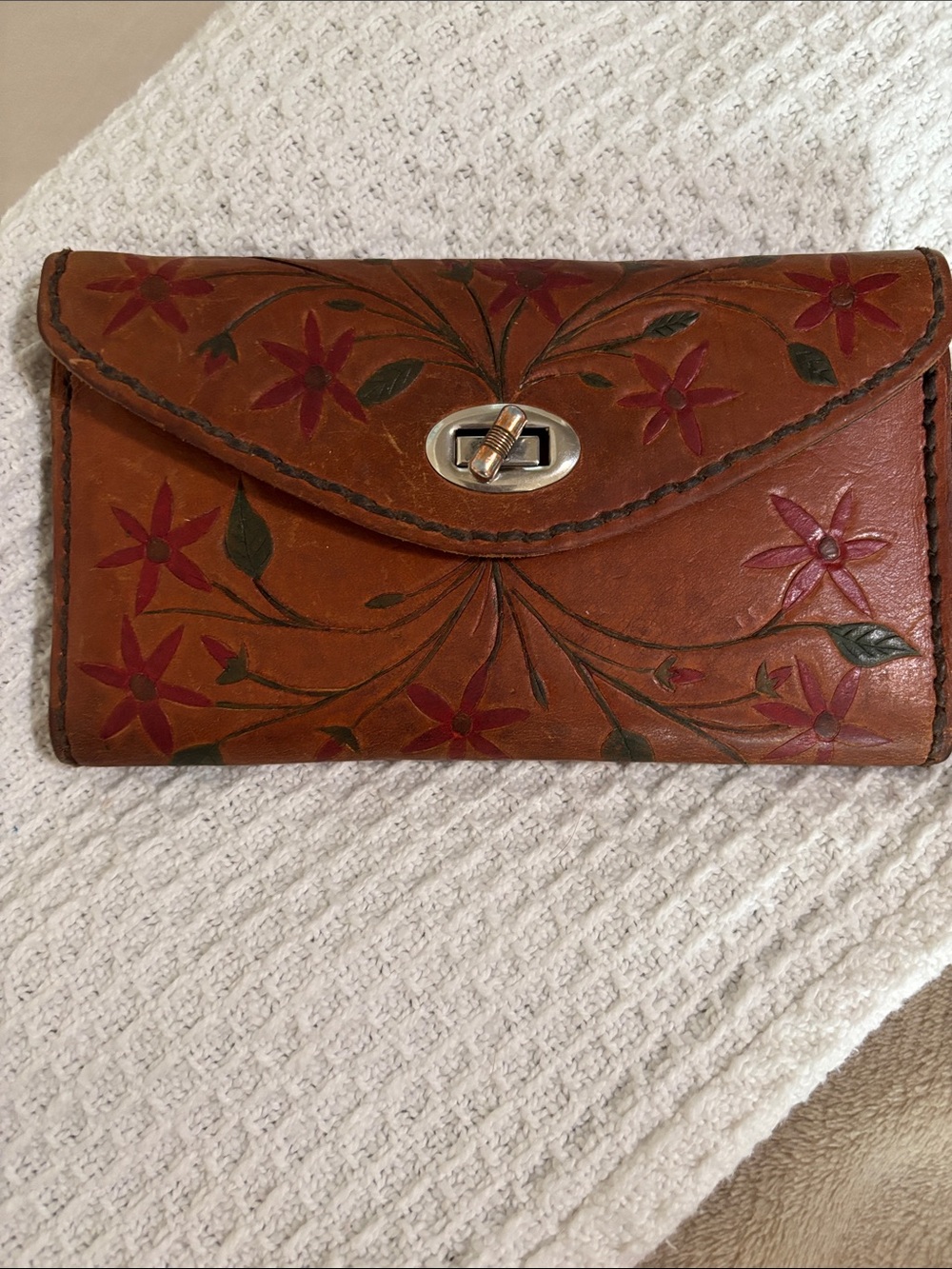 This item is a vintage, hand-tooled leather wallet clutch